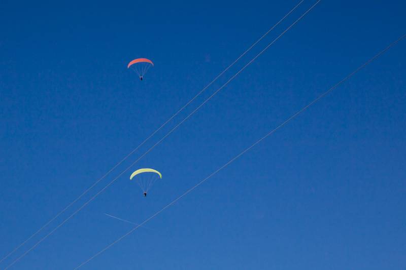 Paragliders in clear blue sky over Zwölferhorn mountain, Austria