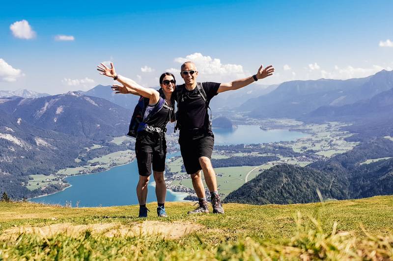Couple standing on Zwölferhorn mountain, with views of Lake Wolfgang