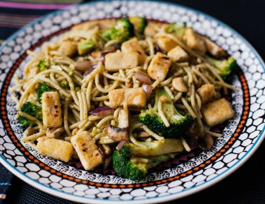 Vegan meal of tofu, broccoli, spaghetti and cashew nuts with pesto